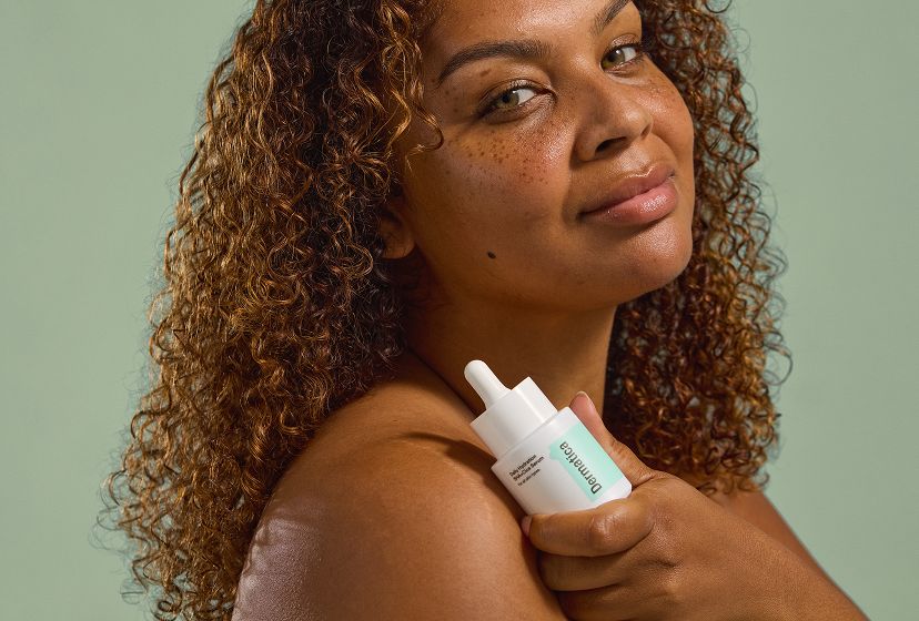 A model posing with a bottle of Daily Hydration Serum