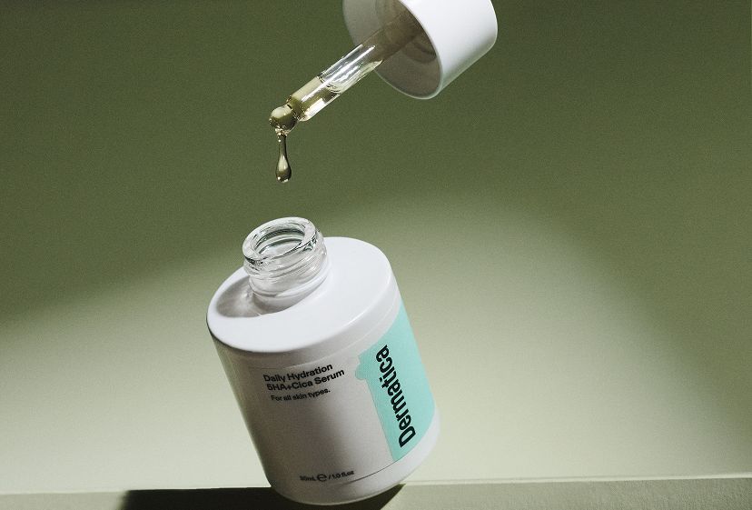 A bottle of Daily Hydration Serum with the lid removed and serum dropping from the attached pipette