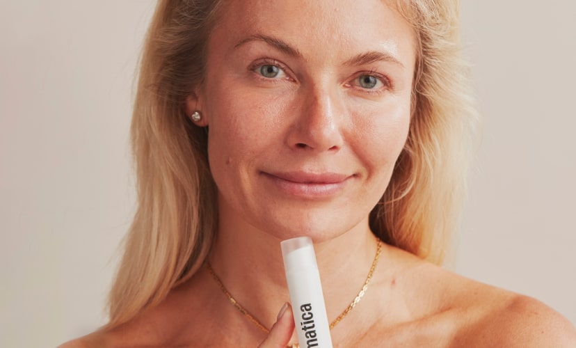 Dermatica - Smiling woman holding Dermatica bottle in the hand