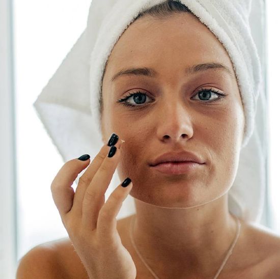 Woman with towel applying treatment